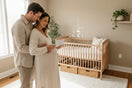 Werdende Eltern im Babyzimmer bei der Suche nach einem Babynamen – Babynamen-Finder von BabyLions®