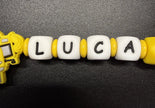 Personalisierte Schnullerkette Bagger mit Namen Luca und gelben Holzlinsen