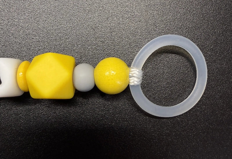 Detail der Schnullerkette Bagger mit gelber Hexagonperle, Holzperle und Schnullerring