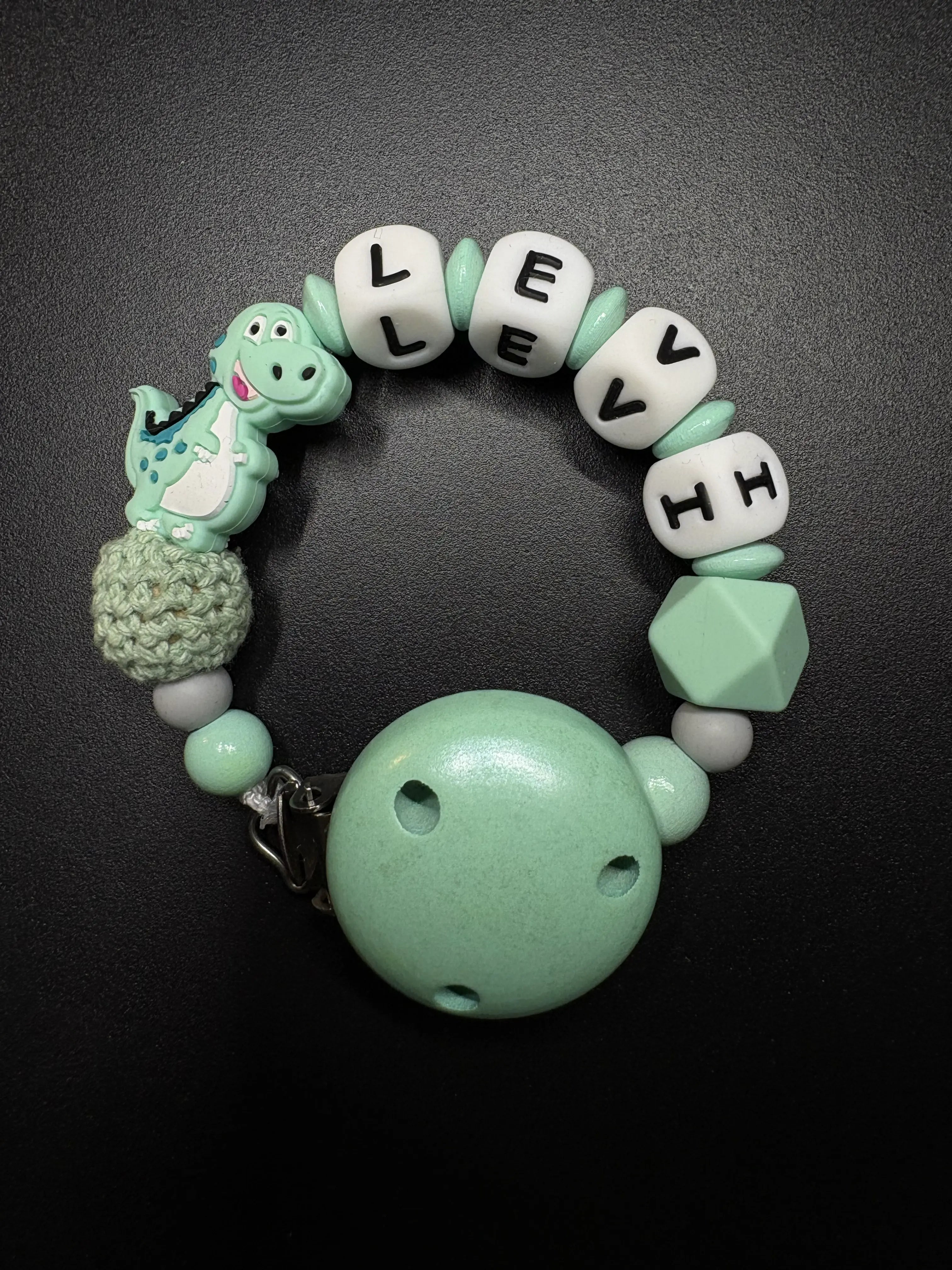 Personalisierte Schnullerkette Dino mit Namen in Mint aus Silikon- und Holzperlen mit Holzclip und Silikonring von BabyLions®