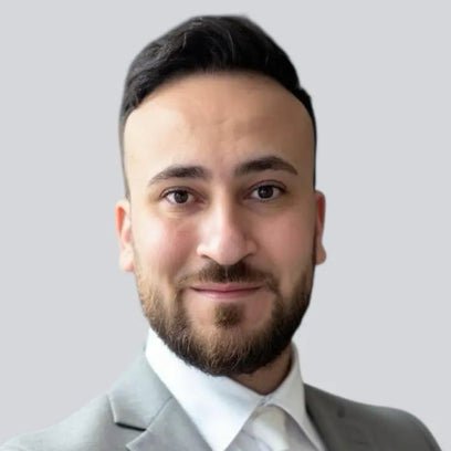 Porträtfoto des Gründers von BabyLions im hellgrauen Anzug mit weißem Hemd vor einfarbig grauem Hintergrund – professionelle Vorstellung im Teamprofil.