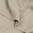 Nahaufnahme der beigen Babydecke aus 100 % Baumwolle mit feiner Strickstruktur und weicher Oberfläche – Detailansicht des Stoffes.