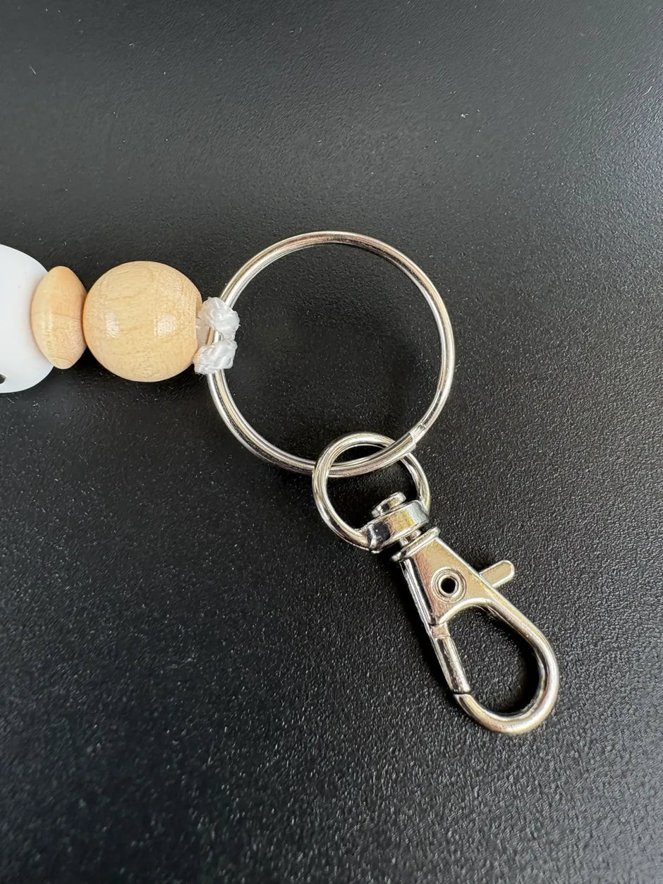 Detailansicht des personalisierten BabyLions Schlüsselanhängers WILD mit Holzperle, Schlüsselring und Karabiner