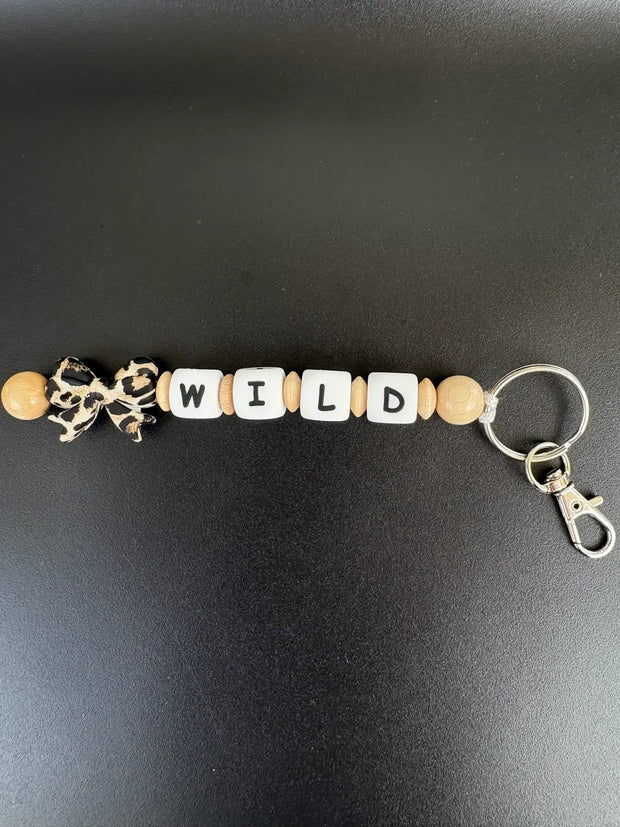 Personalisierter BabyLions Schlüsselanhänger WILD mit Leoparden-Schleife, Buchstabenperlen, Holzperlen und Karabiner