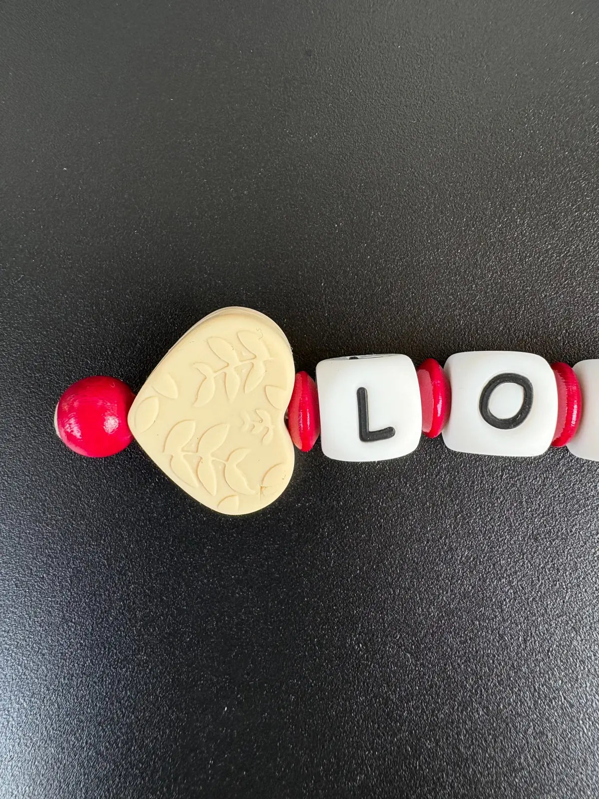 Detailansicht personalisierter Schlüsselanhänger mit LOVE Buchstaben, Holzherz und roten Perlen von BabyLions®