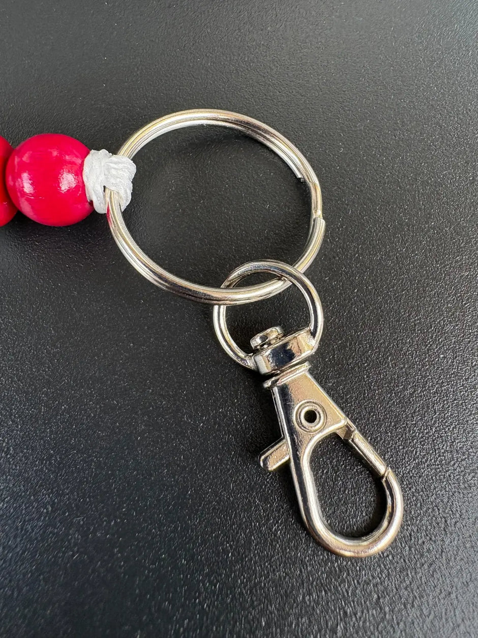 Detailansicht des LOVE Schlüsselanhängers mit roter Perle, Metallring und Karabiner von BabyLions®