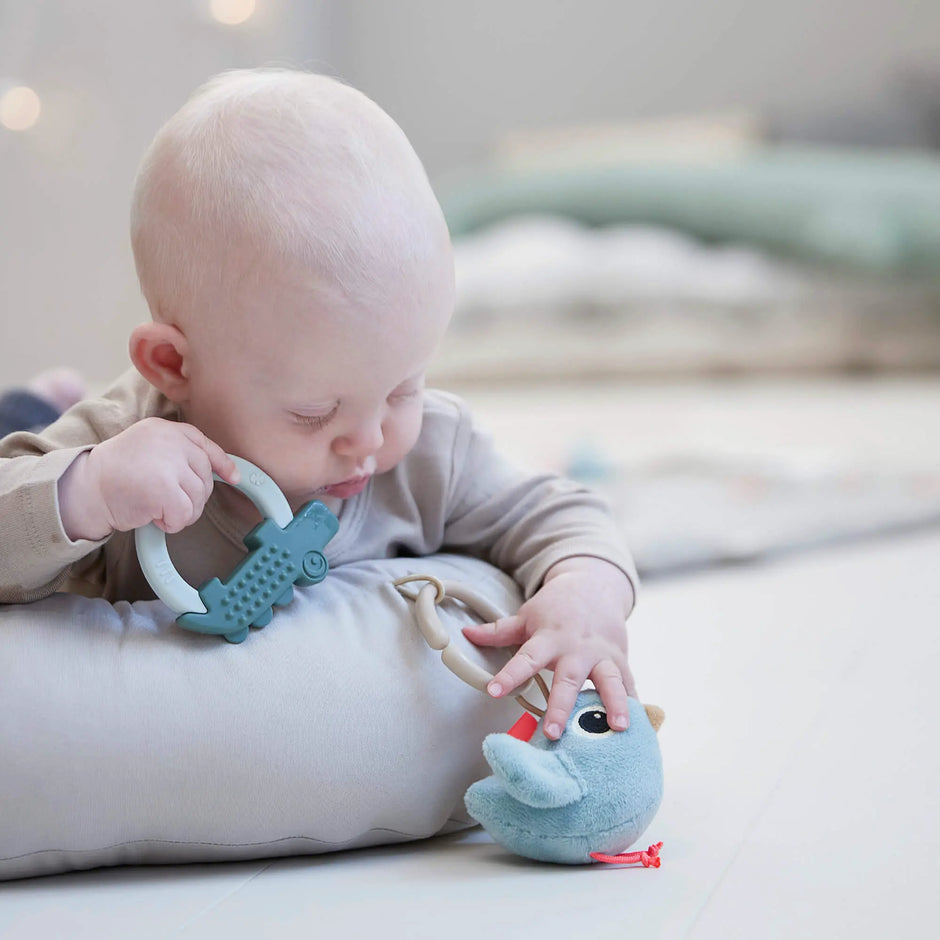 Baby spielt mit Spielzeug im Baby Nest Raffi Done by Deer fördert Greifen und Motorik