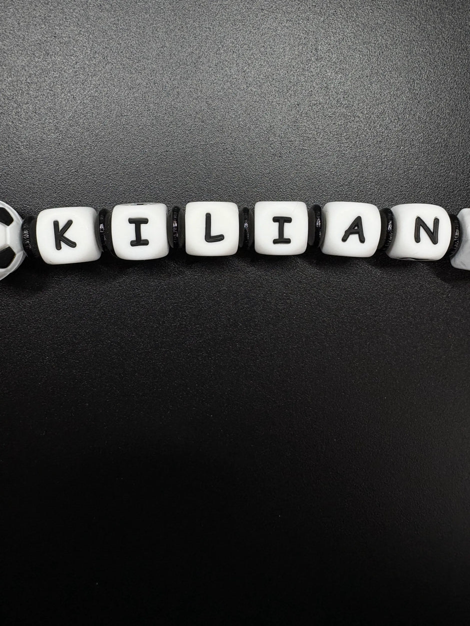 Detailaufnahme der personalisierten Fußball Schnullerkette mit dem Namen Kilian in Schwarz und Weiß