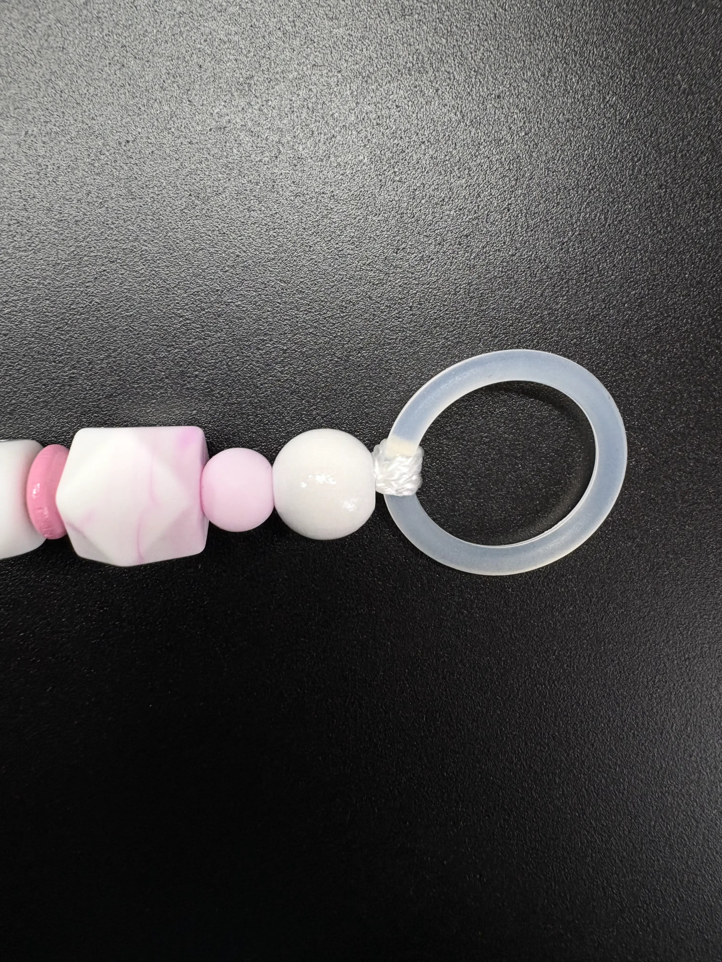 Detailaufnahme des transparenten Silikonrings der personalisierten Schnullerkette Luna in Rosa