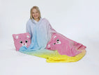 Mädchen mit weicher Kuscheldecke in Regenbogenfarben und zwei rosa Bärenkissen auf weißem Hintergrund.