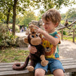Kleinkind sitzt auf einer Bank und spielt mit einem Affen Kuscheltier Mama und Baby aus weichem Plüsch