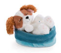 NICI Sleeping Pets Cocker Spaniel Welpe mit braun-weißem Fell, schlafend in einem kuschelweichen blauen Plüschkörbchen.