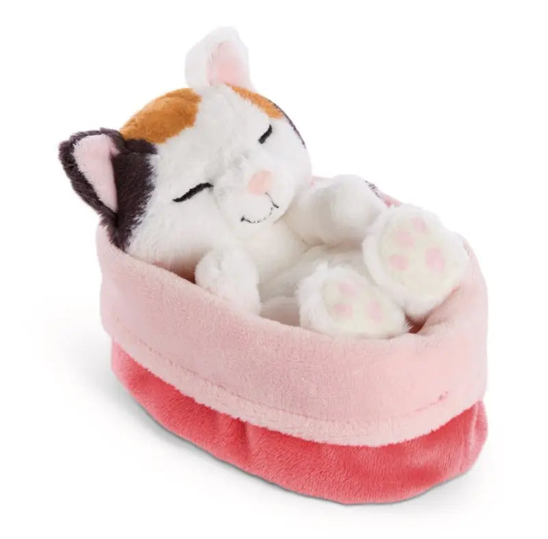 NICI Sleeping Pets Glückskatze mit dreifarbigem Fell und geschlossenen Augen, schlafend im kuschelweichen rosa Plüschkörbchen.