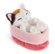 NICI Sleeping Pets Glückskatze mit dreifarbigem Fell und geschlossenen Augen, schlafend im kuschelweichen rosa Plüschkörbchen.