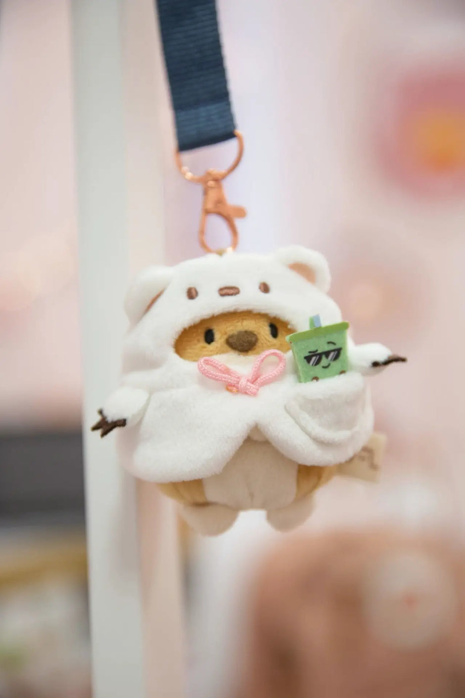 NICI mymochi Shiba Inu Hiro im weißen Bärenkostüm mit Bubble Tea als niedlicher Plüschanhänger an einem Taschenkarabiner.