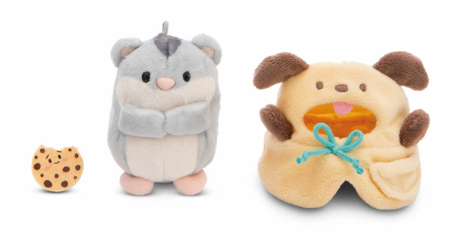 NICI mymochi Hamster Shai mit separatem gelbem Hundekostüm und kleinem Plüschkeks als Zubehör.