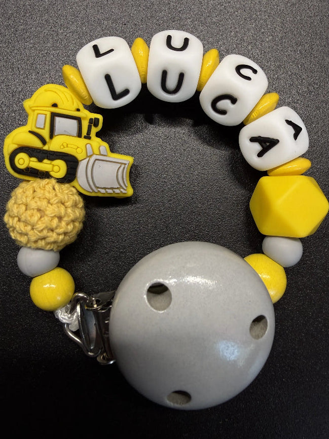 Handgemachte Schnullerkette Bagger mit Namen in Gelb mit Holzclip von BabyLions®
