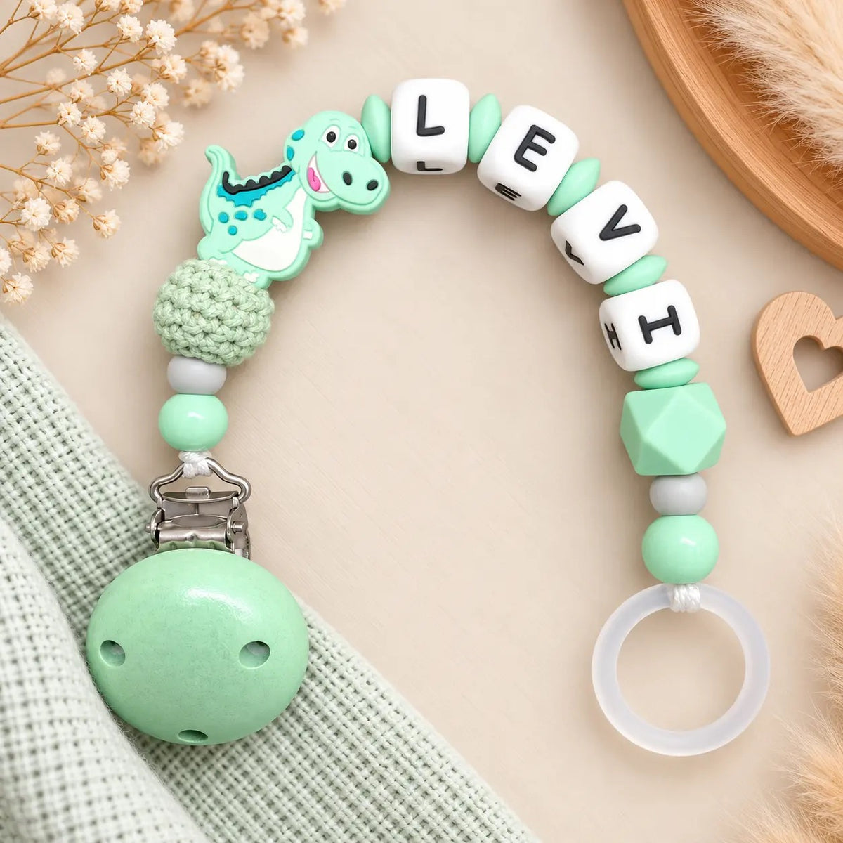Personalisierte Schnullerkette mit Namen Levi und Dino-Motiv in Mintgrün
