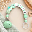 Personalisierte Schnullerkette mit Namen Levi und Dino-Motiv in Mintgrün