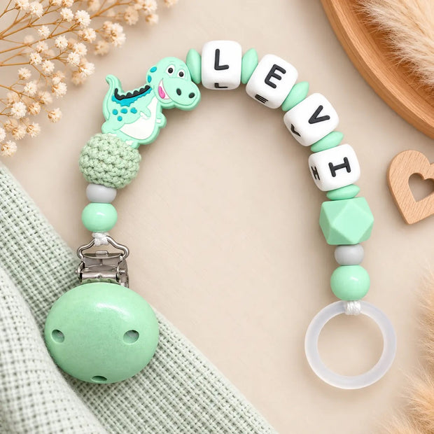 Personalisierte Schnullerkette mit Namen Levi und Dino-Motiv in Mintgrün