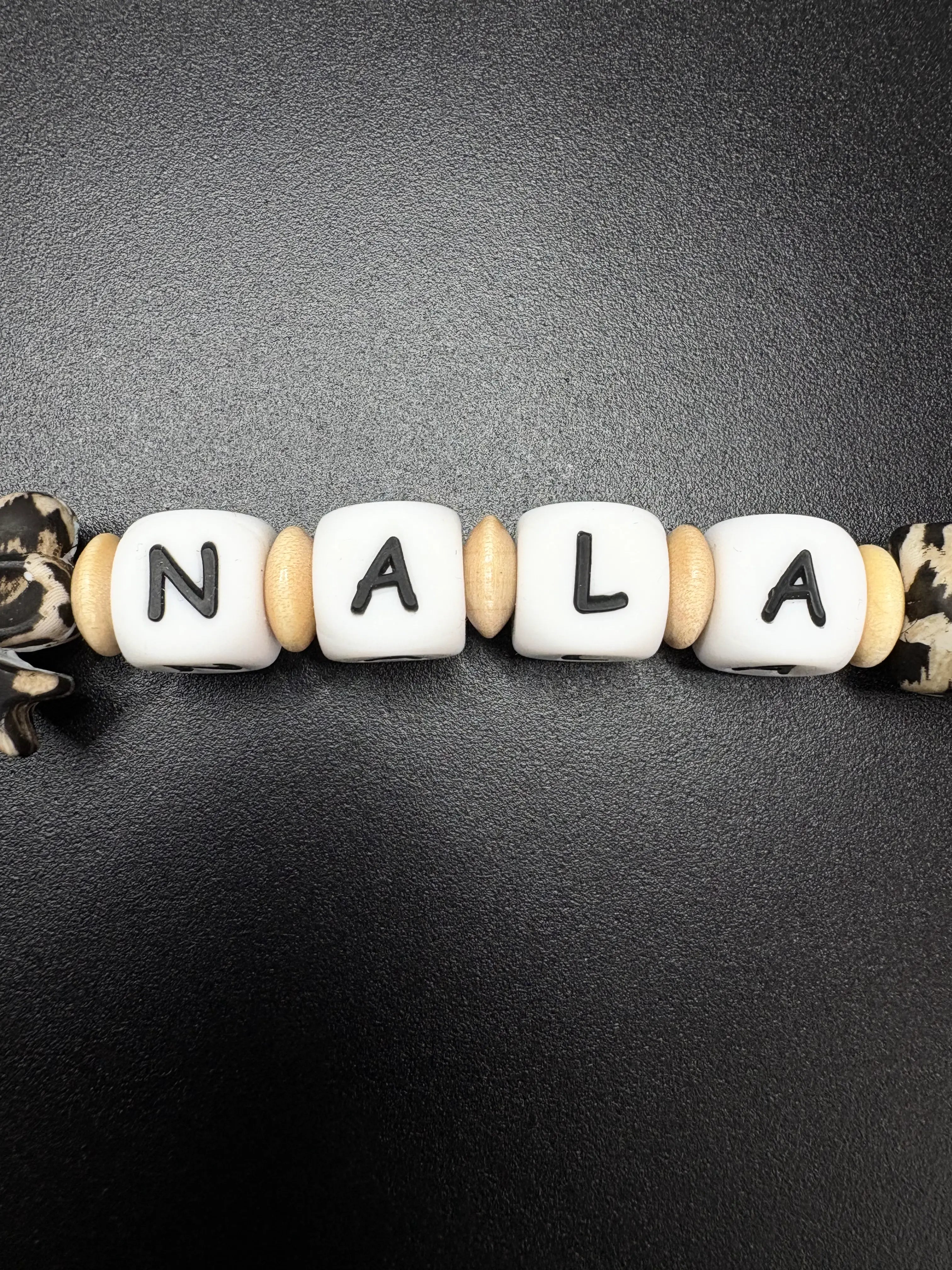 Namensperlen Nala auf personalisierter Schnullerkette mit Leopardenmuster und Holzringen