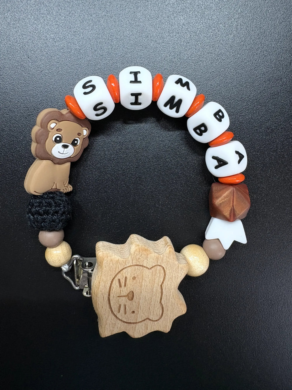 Personalisierte Schnullerkette Simba mit Löwenmotiv, Holzclip, weißen Namensperlen und orangefarbenen Akzenten