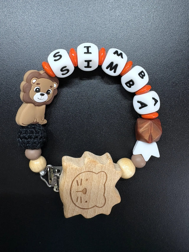 Personalisierte Schnullerkette Simba mit Löwenmotiv, Holzclip, weißen Namensperlen und orangefarbenen Akzenten