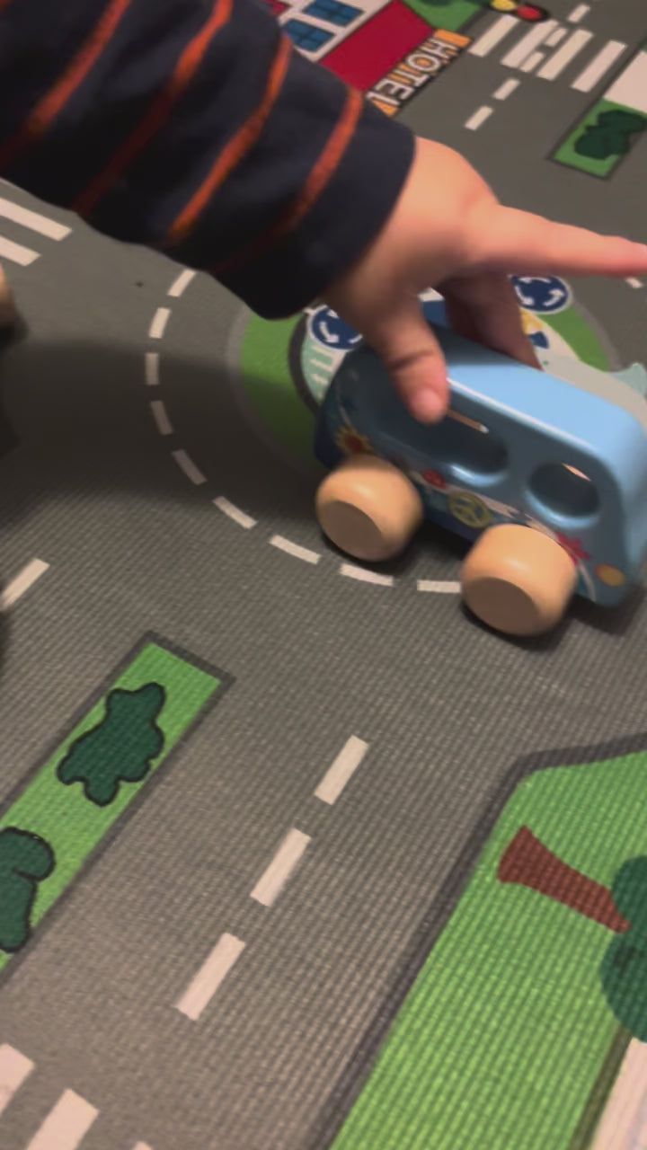 Kind spielt mit Holzauto Spielzeug auf Spielteppich – Baby und Kleinkind Spielzeug