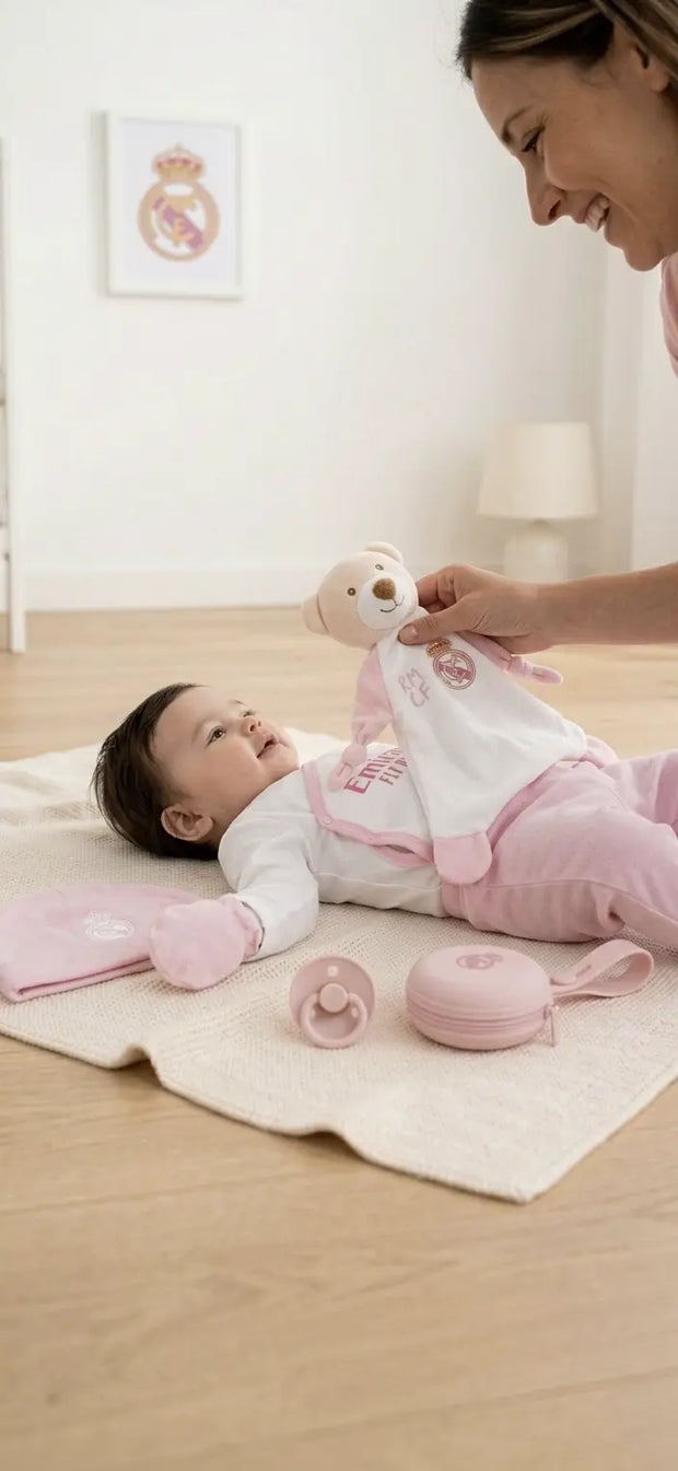 Baby mit Real Madrid Newborn Premium Bundle in Rosa auf Spieldecke mit Schmusetuch, Schnuller, Schnullerhalter und Baby-Erstausstattung – offizielles Real Madrid Lizenzprodukt von BabyLions®